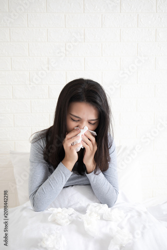 A young Chinese woman with a cold on her bed