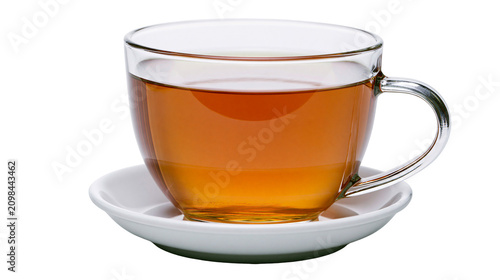Photography Clear glass teacup filled with amber tea resting on a white saucer, isolated on