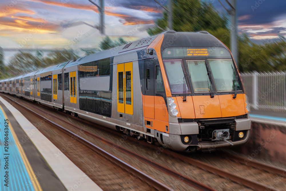 Obraz premium Passenger Train going through Lewisham Train Station at Sunset a suburban Sydney train Station in Sydney NSW Australia