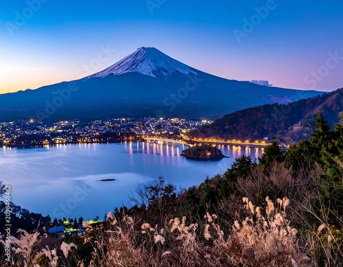 Majestic mountain peak overlooking a sparkling city and calm lake at dusk