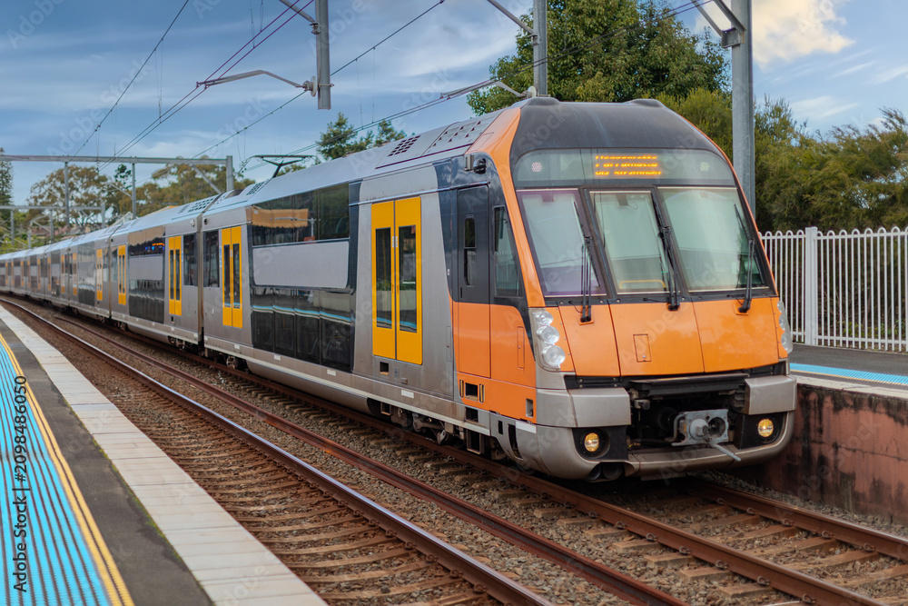 Obraz premium Passenger Train going through Lewisham Train Station at Sunset a suburban Sydney train Station in Sydney NSW Australia