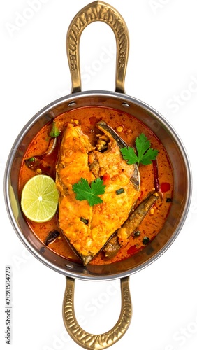 Spicy fish curry served in traditional bowl with lime and garnish