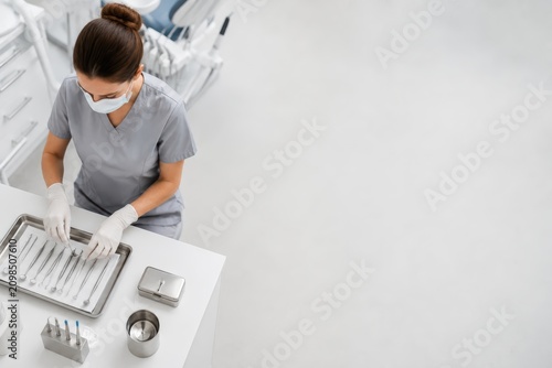 Dental Hygienist Preparing Sterile Instruments in Modern Treatment Room