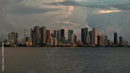 Cinematic day-to-night timelapse of the Mumbai skyline viewed across the Arabian Sea. Showcasing the city's iconic waterfront, urban growth, and vibrant metropolitan atmosphere in Maharashtra, India.