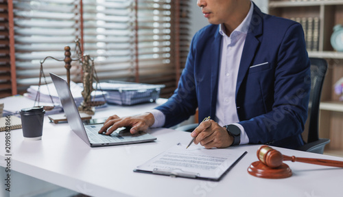 Lawyer working on laptop and signing legal document