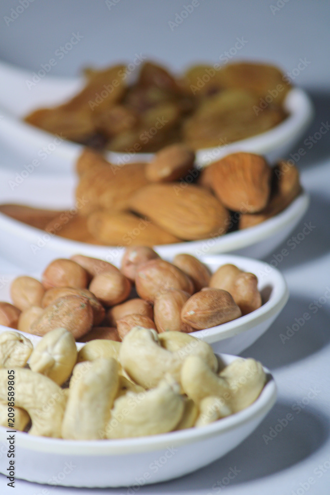 Fototapeta premium dried fruits and nuts on white spoons isolated on white background 