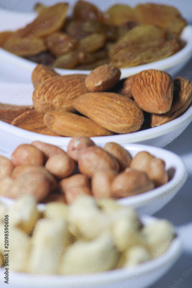 Fototapeta premium dried fruits and nuts on white spoons isolated on white background 