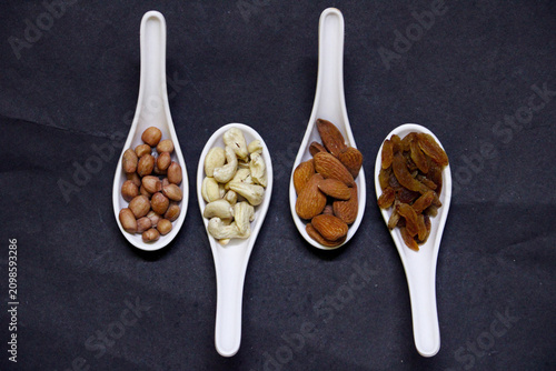 dried fruits and nuts on white spoons