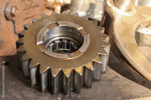 Photos Detailed macro view of a heavy duty steel spur gear wheel and internal needle roller bearing mechanism inside a machine repair workshop