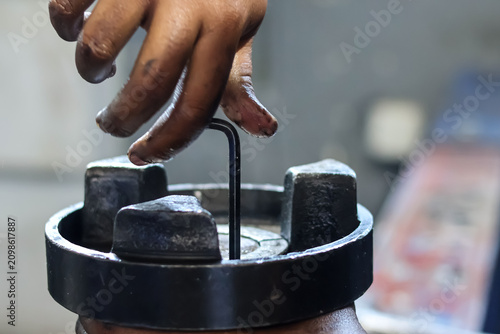 Quadro su tela Mechanic hand using allen key tool to fix engine component.