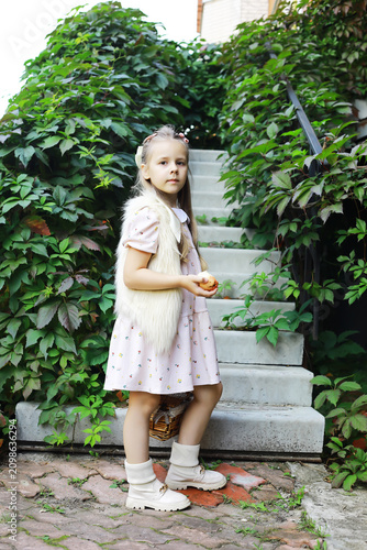 Canvas Print Young Girl in Vintage Outfit Holding Apple on Garden Stairs