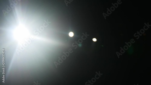 Flashes and glare on a black background, spotlight on the concert