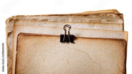 Stack of old cracked paper sheets held by a black binder clip, isolated on transparent background