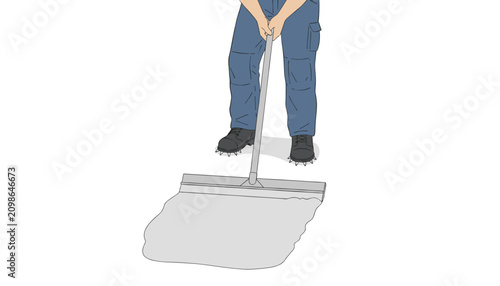 Person wearing spiked shoes and work pants using long-handled metal tool to spread floor compound.