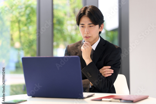 パソコン作業で悩むビジネスマン