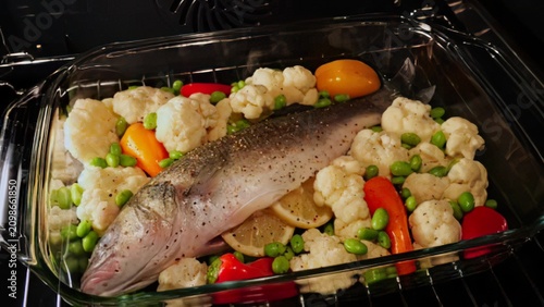 Bild auf Leinwand Fresh fish with vegetables in oven on baking tray