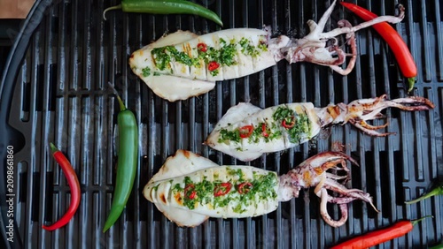 Фотография Fresh fish on a grill with vegetables and herbs