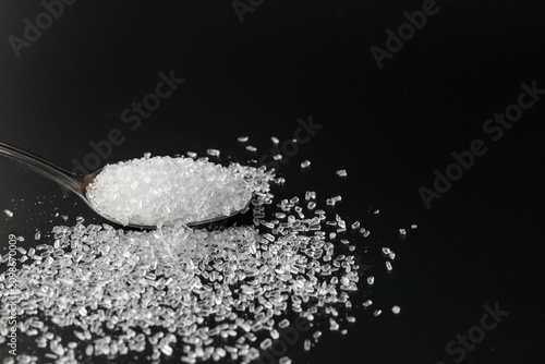 фотографія Spoonful of white Epsom salt crystals, black background