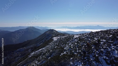 Aerial drone view of rocky mountain ridge with first snow in autumn