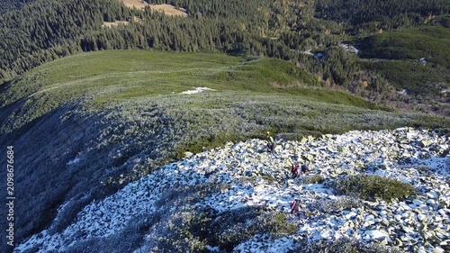 Drone flight over snow-dusted rocks and alpine vegetation in autumn