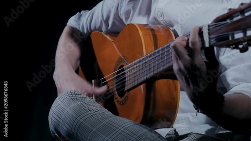 Guitarist strumming warm classical guitar in intimate live music studio session