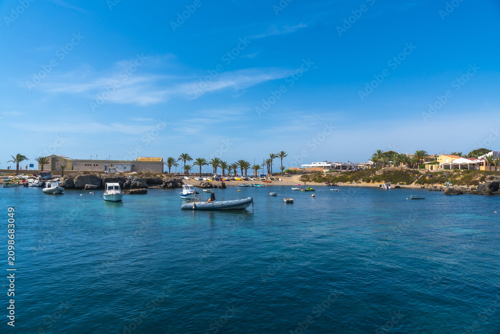 Obraz premium Tabarca island harbor showcasing boats and coastal resort during summer