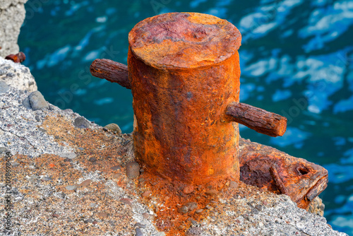 Old, rusting bollard at the harbor