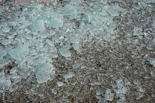 Broken glass from a safety window lies scattered on the ground.