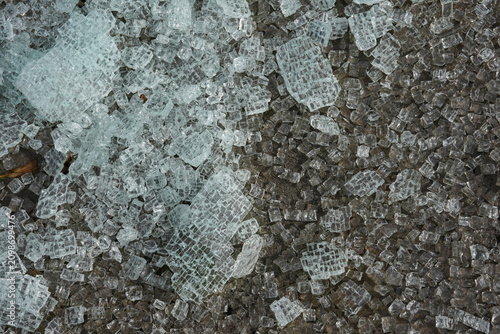 Broken glass from a safety window lies scattered on the ground.