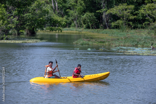 SIGIRIYA, SRI LANKA - JUNE 10, 2026 : A father and son paddle a kayak on Thalkote Lake at Sigiriya in Sri Lanka.