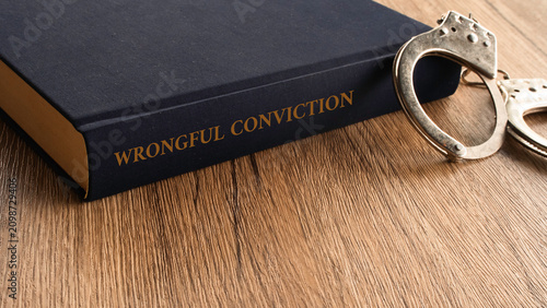 Wrongful Conviction law book spine next to metal handcuffs