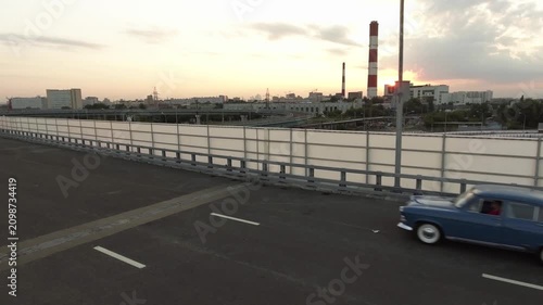 A retro Volga car from the days of the USSR is driving on an overpass in the city