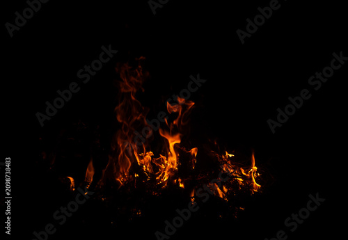 Obraz na płótnie Bright orange flames burning against a dark black background, creating a dramati