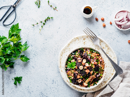 Vegetarian diet salad with beet, buckwheat grains, mushrooms, red onion and fresh herbs in bowl. Warm buckwheat and beetroot salad on gray concrete background. Top view. Copy space