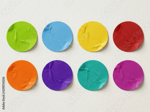 Set of eight colorful round circle stickers with a bright glossy texture and soft drop shadows arranged in two rows isolated on white background