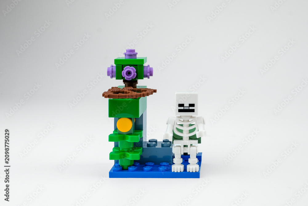 Obraz premium A Minecraft-style skeleton toy with a bow stands beside a fantasy block structure on a white background on Apr 13, 2026 in Jakarta, Indonesia