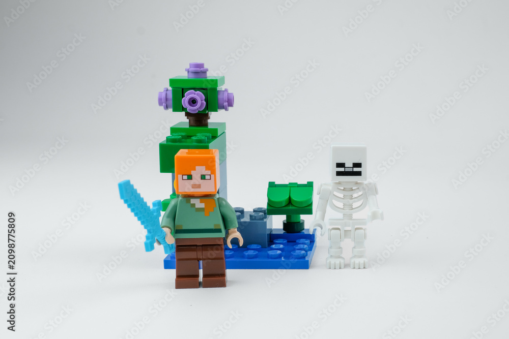 Obraz premium A Minecraft-style block toy character stands with a blue sword in front of a skeleton figure and fantasy toy structure on a white background on Apr 13, 2026 in Jakarta, Indonesia