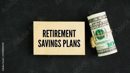 Foto A roll of paper money and papers with the words retirement savings plans