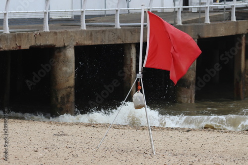 Red flag, signifying 'do not swim' , on beach at Clacton on Sea, Essex, UK