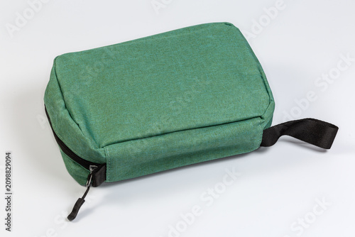 Zipped small fabric travel accessories bag on gray background