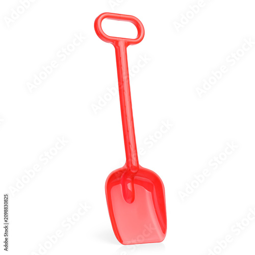 A red plastic toy shovel or shovel for children playing with snow or sand.