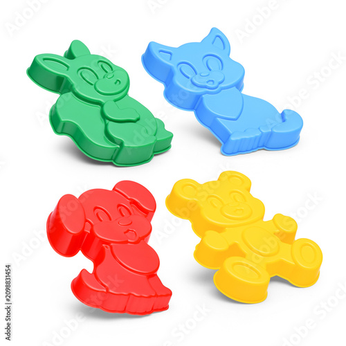 Four plastic animal sand molds in various colors on white background