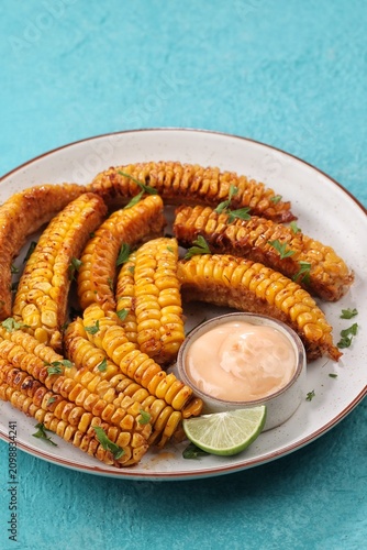 Corn ribs served with flavorful seasoning and dipping sauce. Fresh corn on the cob cut into rib-shaped wedges, baked, roasted, or air-fried until golden and tender.