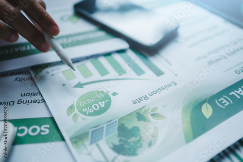 ESG report emission reduction carbon footprint sustainability goals net zero 2030 strategy, pointing stylus at environmental chart tracking performance green corporate responsibility climate action