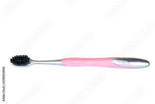 Pink and silver toothbrush with black bristles isolated on a white background. Personal oral care hygiene tool with copy space, ideal for healthcare, dental care, hygiene, and product advertising.