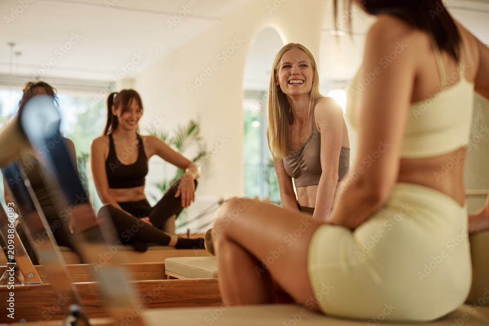 Obraz premium Women laughing enjoying a pilates class in studio
