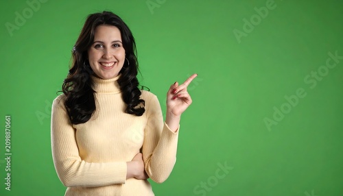 Woman pointing right on green background
