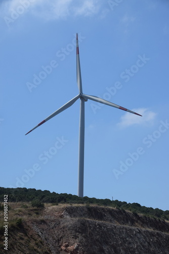 Windmills photographed against a clear sky background.