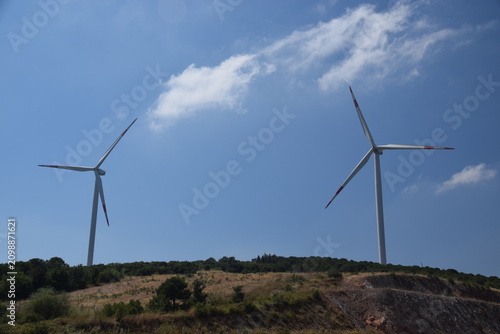 Windmills photographed against a clear sky background.