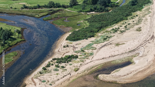 Photography Aerial view river estuary meeting coastal sand dunesRiver estuary winding thro